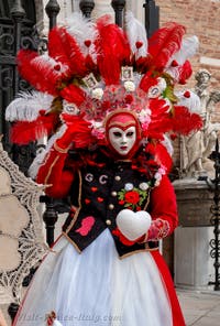 People in costume at the Venice Carnival in front of the Venetian Arsenal.