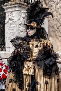 People in costume at the Venice Carnival in front of the Venetian Arsenal.