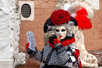 People in costume at the Venice Carnival in front of the Venetian Arsenal.