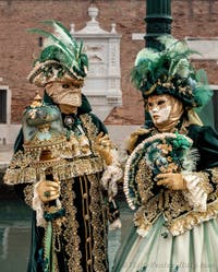 People in costume at the Venice Carnival in front of the Venetian Arsenal.