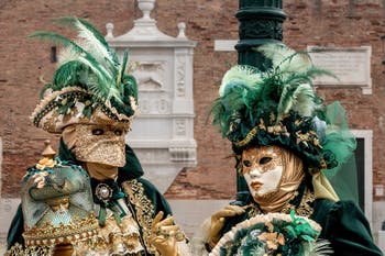 People in costume at the Venice Carnival in front of the Venetian Arsenal.