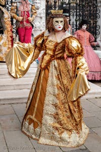 People in costume at the Venice Carnival in front of the Venetian Arsenal.