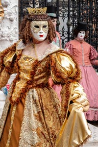 People in costume at the Venice Carnival in front of the Venetian Arsenal.