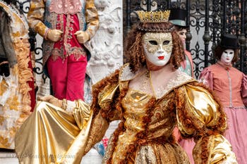 People in costume at the Venice Carnival in front of the Venetian Arsenal.