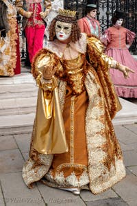 People in costume at the Venice Carnival in front of the Venetian Arsenal.