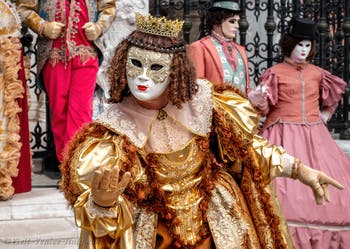 People in costume at the Venice Carnival in front of the Venetian Arsenal.