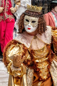 People in costume at the Venice Carnival in front of the Venetian Arsenal.