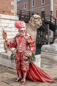 People in costume at the Venice Carnival in front of the Venetian Arsenal.