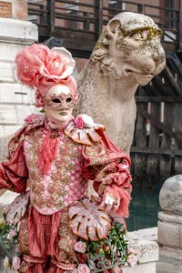 People in costume at the Venice Carnival in front of the Venetian Arsenal.