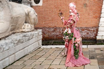 People in costume at the Venice Carnival in front of the Venetian Arsenal.