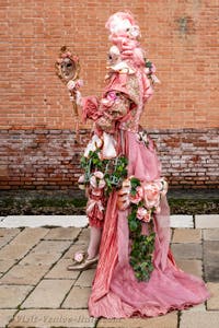 People in costume at the Venice Carnival in front of the Venetian Arsenal.