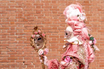 People in costume at the Venice Carnival in front of the Venetian Arsenal.