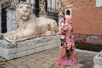 People in costume at the Venice Carnival in front of the Venetian Arsenal.