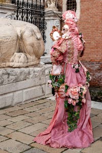 People in costume at the Venice Carnival in front of the Venetian Arsenal.