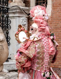 People in costume at the Venice Carnival in front of the Venetian Arsenal.