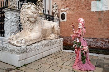 People in costume at the Venice Carnival in front of the Venetian Arsenal.