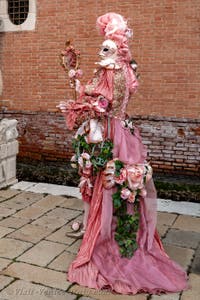 People in costume at the Venice Carnival in front of the Venetian Arsenal.