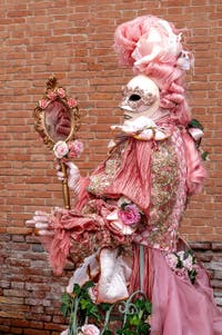 People in costume at the Venice Carnival in front of the Venetian Arsenal.