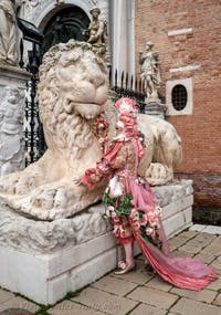 People in costume at the Venice Carnival in front of the Venetian Arsenal.