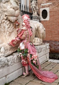 People in costume at the Venice Carnival in front of the Venetian Arsenal.