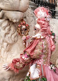 People in costume at the Venice Carnival in front of the Venetian Arsenal.