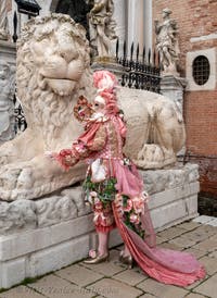 People in costume at the Venice Carnival in front of the Venetian Arsenal.