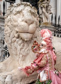 People in costume at the Venice Carnival in front of the Venetian Arsenal.