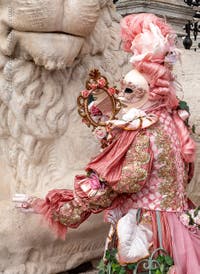 People in costume at the Venice Carnival in front of the Venetian Arsenal.