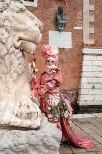 People in costume at the Venice Carnival in front of the Venetian Arsenal.