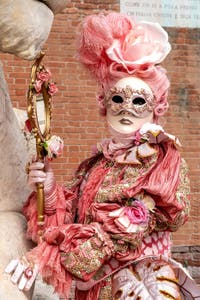 People in costume at the Venice Carnival in front of the Venetian Arsenal.