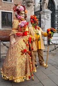 People in costume at the Venice Carnival in front of the Venetian Arsenal.