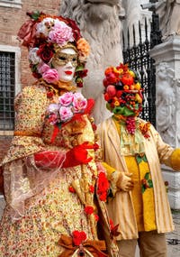 People in costume at the Venice Carnival in front of the Venetian Arsenal.