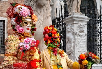 People in costume at the Venice Carnival in front of the Venetian Arsenal.