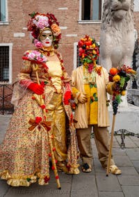 People in costume at the Venice Carnival in front of the Venetian Arsenal.