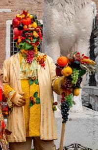 People in costume at the Venice Carnival in front of the Venetian Arsenal.