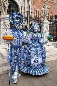 People in costume at the Venice Carnival in front of the Venetian Arsenal.