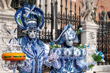 People in costume at the Venice Carnival in front of the Venetian Arsenal.