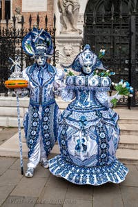 People in costume at the Venice Carnival in front of the Venetian Arsenal.