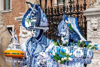 People in costume at the Venice Carnival in front of the Venetian Arsenal.