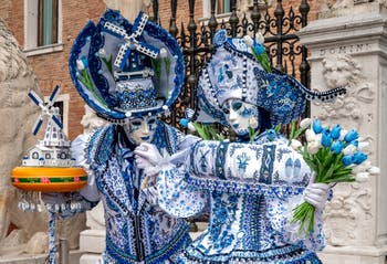 People in costume at the Venice Carnival in front of the Venetian Arsenal.