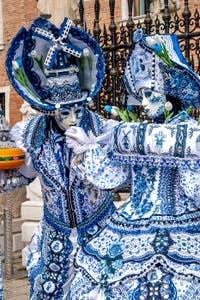 People in costume at the Venice Carnival in front of the Venetian Arsenal.