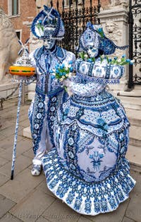 People in costume at the Venice Carnival in front of the Venetian Arsenal.