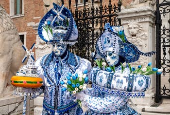 People in costume at the Venice Carnival in front of the Venetian Arsenal.