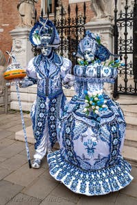 People in costume at the Venice Carnival in front of the Venetian Arsenal.