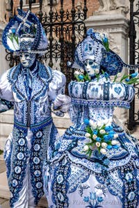 People in costume at the Venice Carnival in front of the Venetian Arsenal.