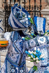 People in costume at the Venice Carnival in front of the Venetian Arsenal.