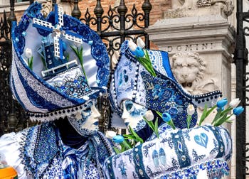 People in costume at the Venice Carnival in front of the Venetian Arsenal.