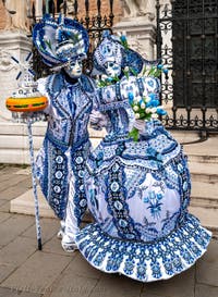 People in costume at the Venice Carnival in front of the Venetian Arsenal.