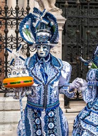 People in costume at the Venice Carnival in front of the Venetian Arsenal.