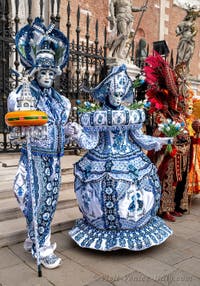 People in costume at the Venice Carnival in front of the Venetian Arsenal.